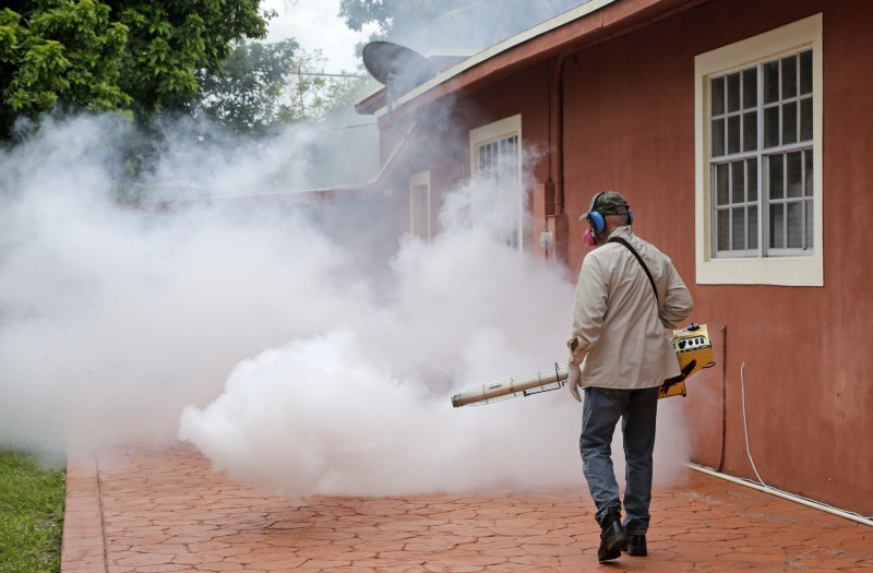 A Miami-Dade County mosquito control worker sprays around a home in the Wynwood area of Miami on Monday, Aug. 1, 2016. CREDIT: AP PHOTO/ALAN DIAZ