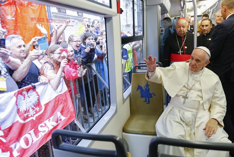 Pope Francis waives to a cheering crowd of faithful as he drives by in a public transportation tram he used to reach the venue of the World Youth Days in Krakow, Poland, Thursday, July 28, 2016. Pope Francis is in Poland for a five-day pastoral visit and to attend the 31st World Youth Days. CREDIT: STEFANO RELLANDINI, AP