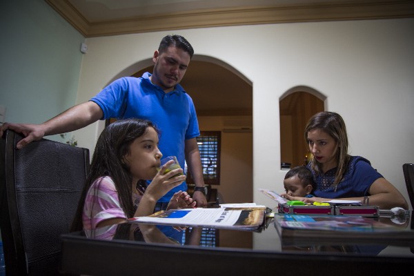 Jesús Ernesto Pérez and Luisa Angelica López wait for their daughter, Valentina, 7, to drink one of four allergy medications she takes daily to prevent painful reactions to air pollution and other irritants. Though Valentina is highly allergic to multiple things, wind events and days of dense contamination seem to be the prime triggers, her parents say. CREDIT: ALEJANDRO DÁVILA FRAGOSO, THINKPROGRESS