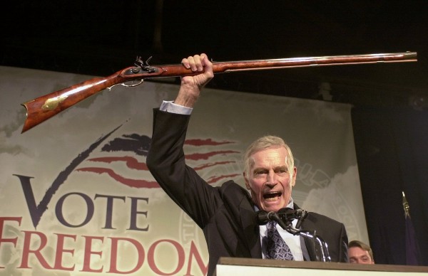NRA President Charlton Heston holds up a rifle as he addresses gun owners during a “get-out-the-vote” rally in Manchester, N.H on Oct. 21, 2002. CREDIT: AP Photo/Jim Cole