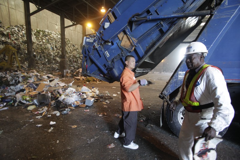 Tuesday, Aug. 24, 2010, a truck driver, left, unloads solid waste operator at the South East Reserve Recovery Facility (SERRF) in Long Beach, Calif. CREDIT: AP PHOTO/DAMIAN DOVARGANES