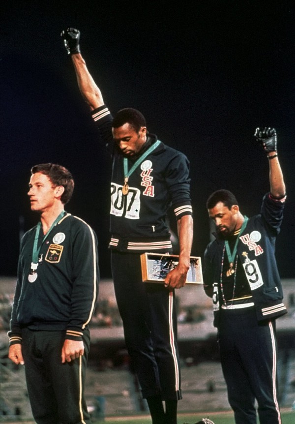 U.S. Athletes Tommie Smith, center, and John Carlos stare downward while extending gloved hands skyward in the black power salute while the Star Spangled Banner plays, after Smith received the gold and Carlos the bronze for the 200 meter run at the 1968 Summer Games in Mexico City. CREDIT: AP PHOTO/FILE