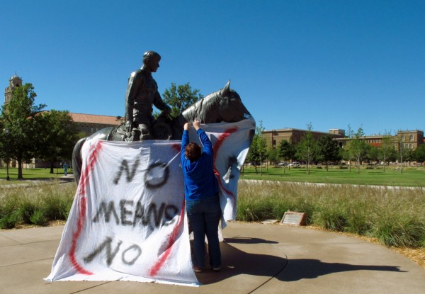 Texas Tech freshman Regan Elder helps drape a bed sheet with the message “ No means No,” over the university’s seal on the Lubbock campus on Wednesday, Oct. 1, 2014. CREDIT: AP/BETSY BLANEY