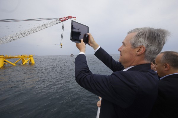 Sen. Sheldon Whitehouse (D-R.I.) photographs the first foundation jacket installed by Deepwater Wind in the nation’s first offshore wind farm construction project in July 2015. CREDIT: AP PHOTO/STEPHAN SAVOIA