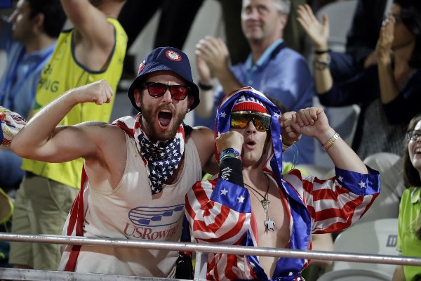 Fans dressed in United States colors cheer during a women’s beach volleyball match at the 2016 Summer Olympics CREDIT: AP PHOTO/MARCIO JOSE SANCHEZ