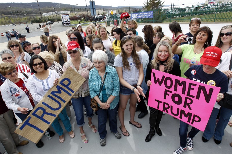 A group of women hold signs and shout their support as they wait on line to attend a rally for Republican presidential candidate Donald Trump in Wilkes-Barre, Pa. CREDIT: AP Photo/Mel Evans