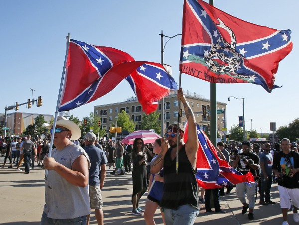 A group carries confederate flags past a Black Lives Matter rally. CREDIT: AP Photo/Sue Ogrocki
