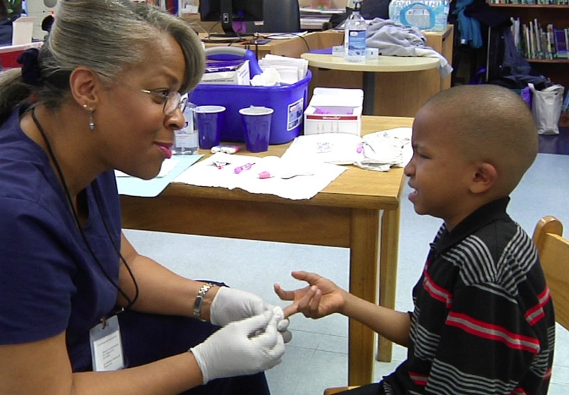 Nurse Veronica Robinson draws blood from 7-year-old boy during a lead-testing clinic held in Flint, Mich. in March. CREDIT: AP Photo/Mike Householder