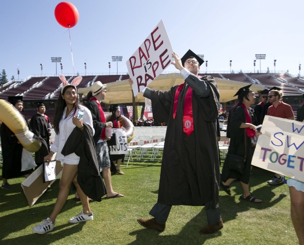 A Stanford graduate holds a sign in protest of former student — now convicted rapist — Brock Turner’s lenient sentence at the university’s June graduation ceremony. CREDIT: AP Photo/D. Ross Cameron