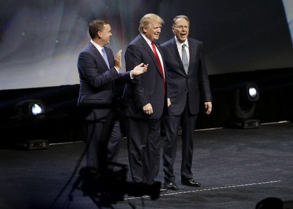 Trump is introduced by NRA executive director Chris W. Cox , left, and NRA executive vice president Wayne LaPierre, right. CREDIT: AP Photo/Mark Humphrey