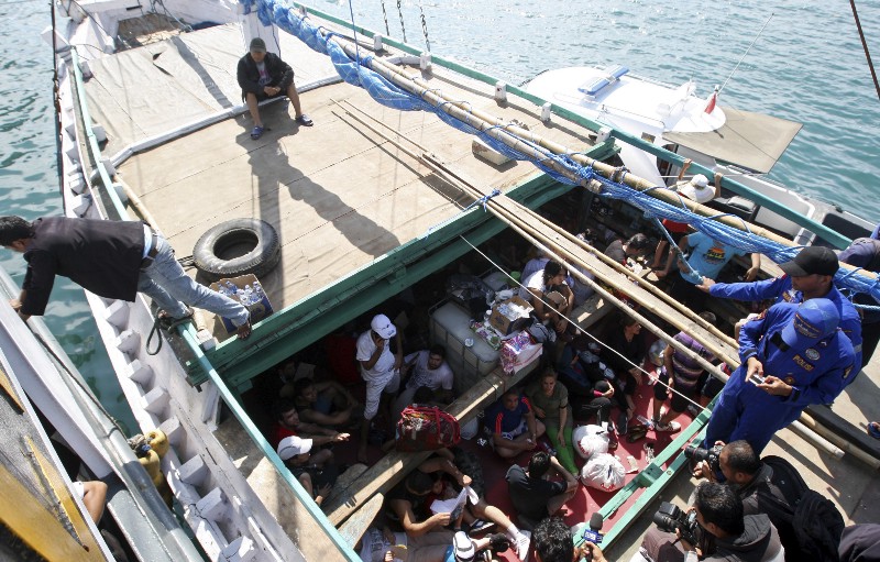 Iranian asylum seekers who were caught in Indonesian waters while sailing to Australia sit on a boat at Benoa port in Bali, Indonesia, May 12, 2013. AP PHOTO/FIRDIA LISNAWATI