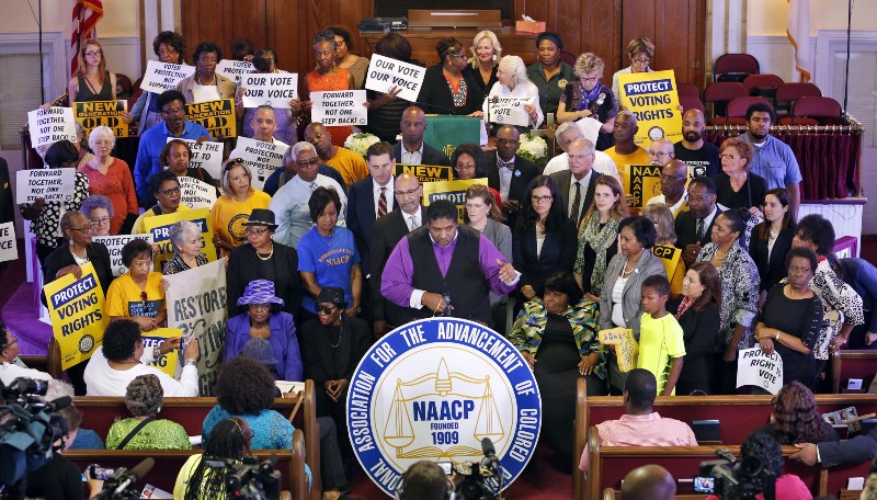 Rev. Dr. William Barber (center) and other voting rights activists. CREDIT: AP Photo/Steve Helber