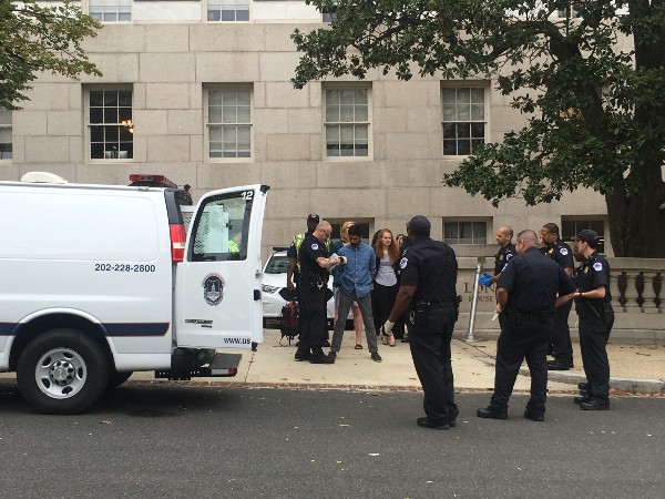 Protesters are handcuffed and escorted in police vans outside the U.S. Capitol. CREDIT: KIRA LERNER
