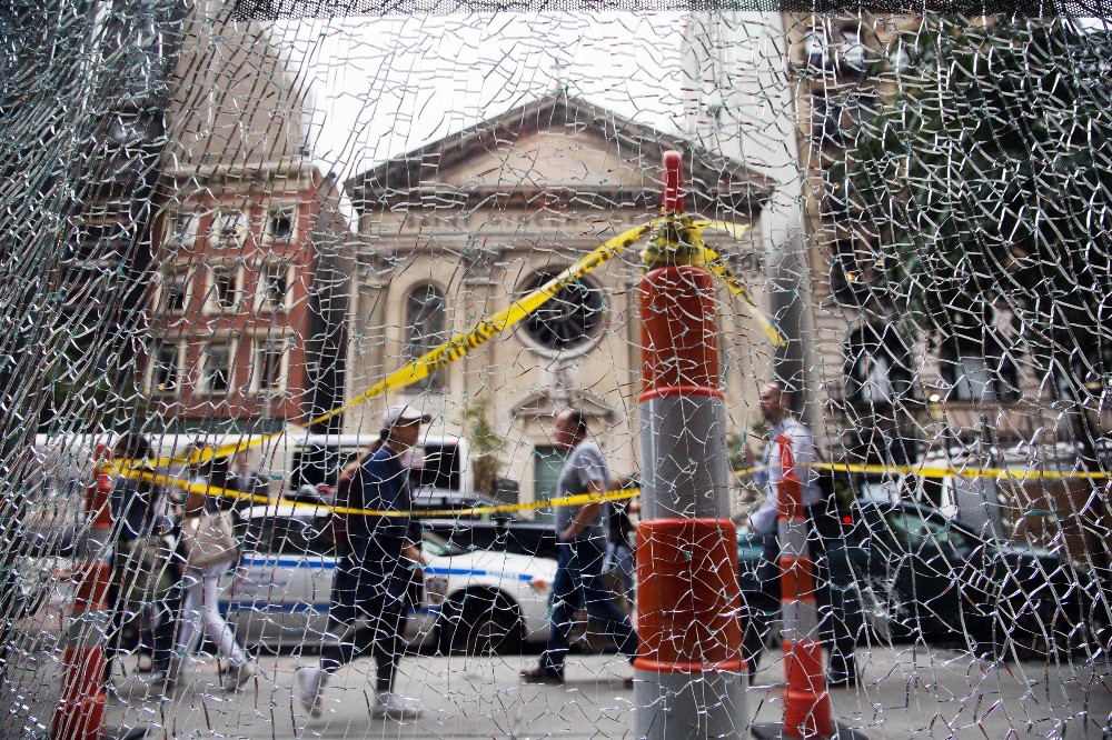 New Yorkers pass a shattered storefront window in Manhattan. The window was hit by shrapnel from the bomb that exploded across the street Saturday evening. CREDIT: AP Photo/Mark Lennihan