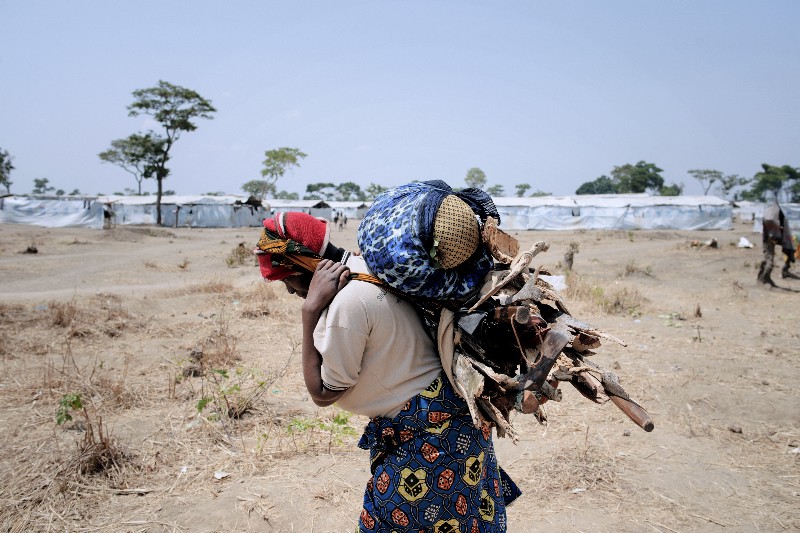 An elderly Burundian refugee woman, Therese Njebarikanye, 70, carrying firewood in Nyarugusu camp in Tanzania. CREDIT: Luca Sola