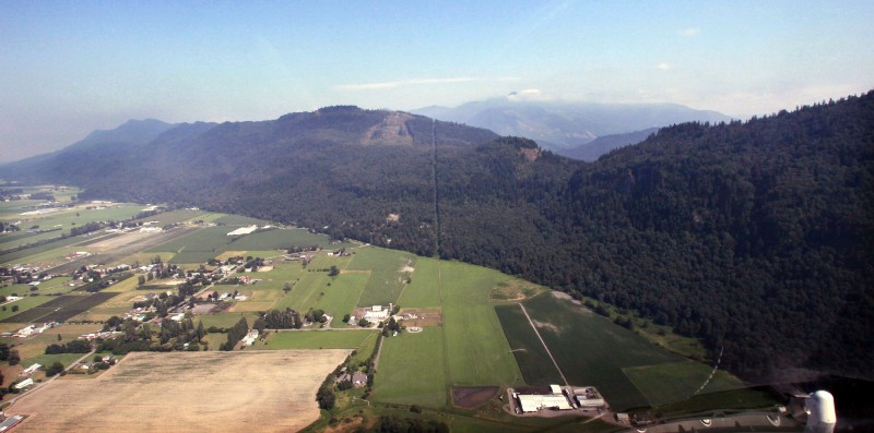 In this 2009 picture, the border between Canada, left, and the U.S. rises from farmland, below, as a narrow clear-cut through alpine forest as it heads into the North Cascades looking east from near Lynden, Wash. AP PHOTO/ELIANE THOMPSON