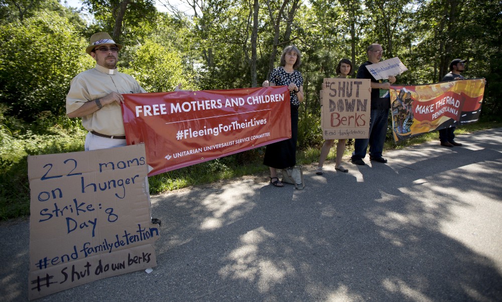 Protesters stand on a roadside near Martha’s Vineyard to protest and call on the attention of President Barack Obama, regarding the detention of undocumented immigrants from Central America in a detention facility in Berks County, PA AP PHOTO/MANUEL BALCE CENETA