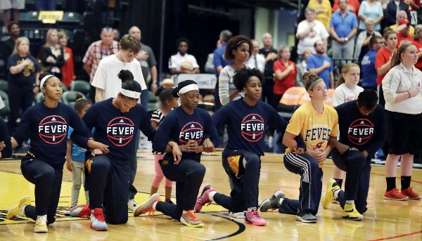 The Indiana Fever take a knee. CREDIT: DARRON CUMMINGS, AP
