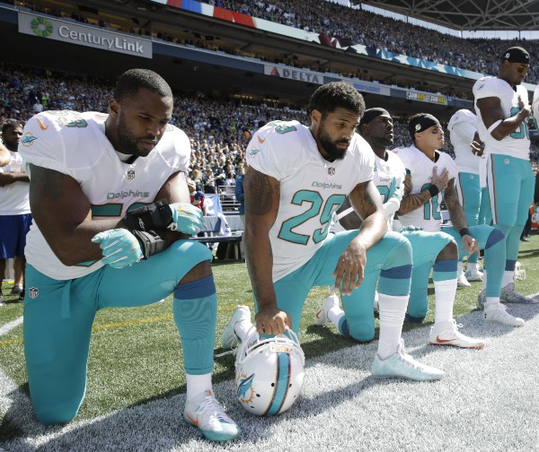 Kneeling from left, Miami Dolphins’ Jelani Jenkins, Arian Foster, Michael Thomas, and Kenny Stills. CREDIT: STEPHEN BRASHEAR, AP
