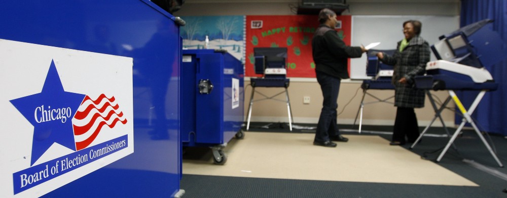 An election worker hands a voting receipt to a voter at a polling station in Chicago, Illinois, Feb. 27, 2012. CREDIT: AP Photo/M. Spencer Green