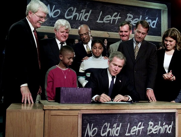 President George W. Bush signs the No Child Left Behind Act of 2001 into law, as Sen. Edward Kennedy (D-MA) looks on. (CREDIT: AP PHOTO/RON EDMONDS, FILE)