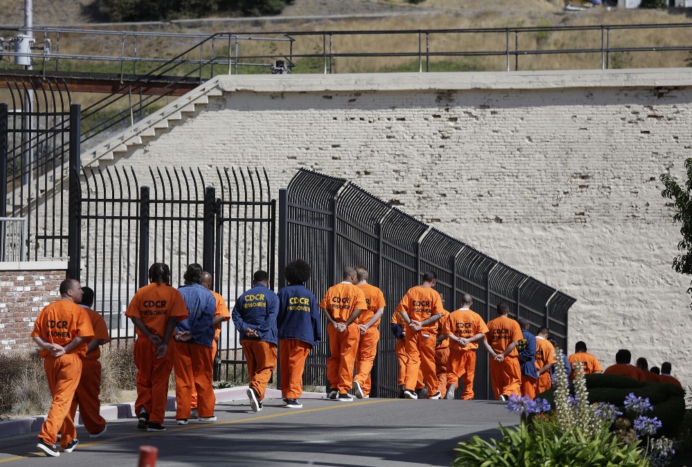 A row of general population inmates walk in a line at San Quentin State Prison. CREDIT: AP PHOTO/ERIC RISBERG