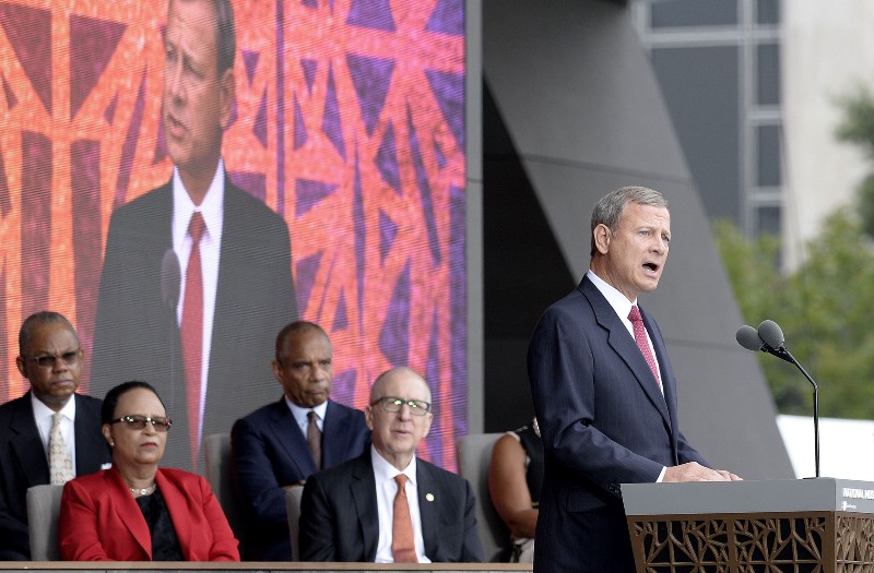 Chief Justice John Roberts speaks at the opening of the National Museum of African American History & Culture weeks after he voted to permit North Carolina to engage in intentional race discrimination. CREDIT: Olivier Douliery / Pool