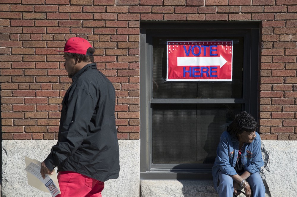 Voters mill about outside the Hamilton County Board of Elections as early voting begins statewide. CREDIT: AP Photo/John Minchillo