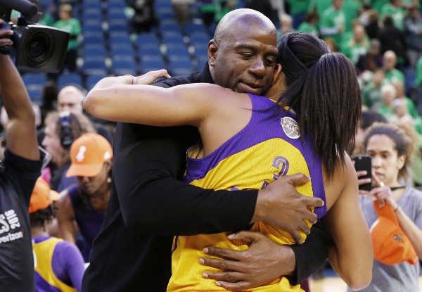 Los Angeles Sparks owner Magic Johnson, left, hugs Candace Parker after the Sparks won the WNBA basketball championship. CREDIT: AP Photo/Jim Mone