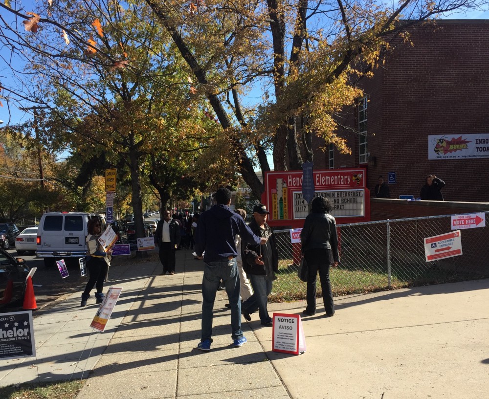Markus Batchelor hands out election literature outside of the Hendley Elementary School polling place in D.C.’s Ward 8. CREDIT: Natasha Geiling