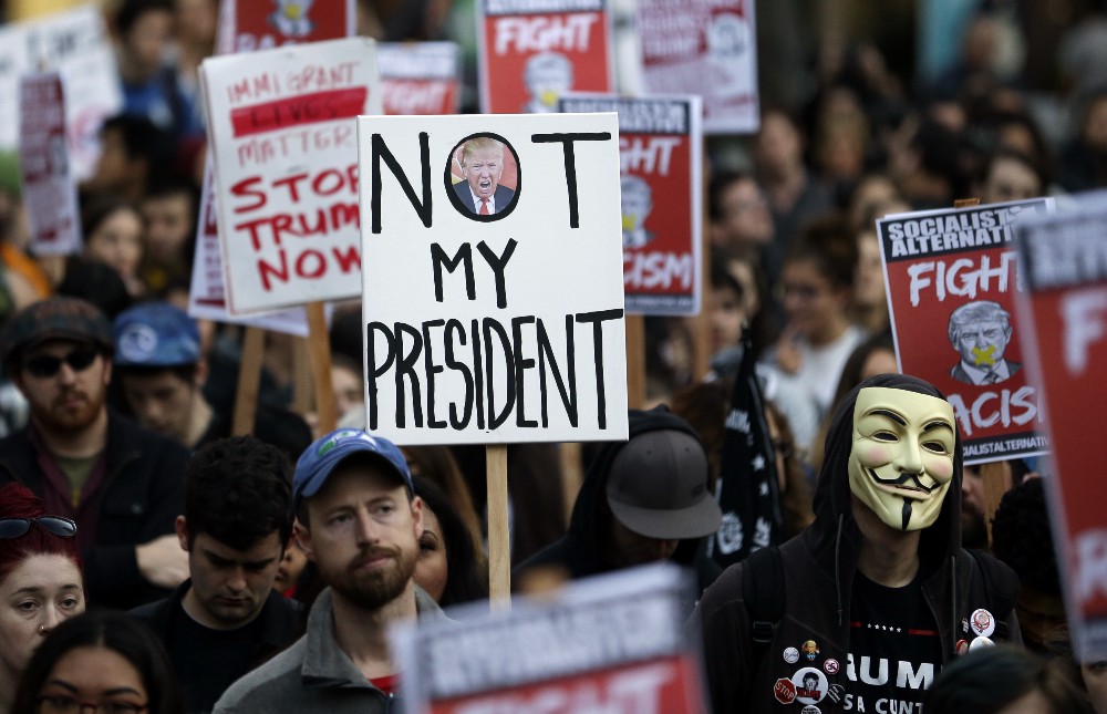Protesters hold signs during a protest against the election of President-elect Donald Trump, Wednesday, Nov. 9, 2016, in downtown Seattle. CREDIT: AP Photo/Ted S. Warren