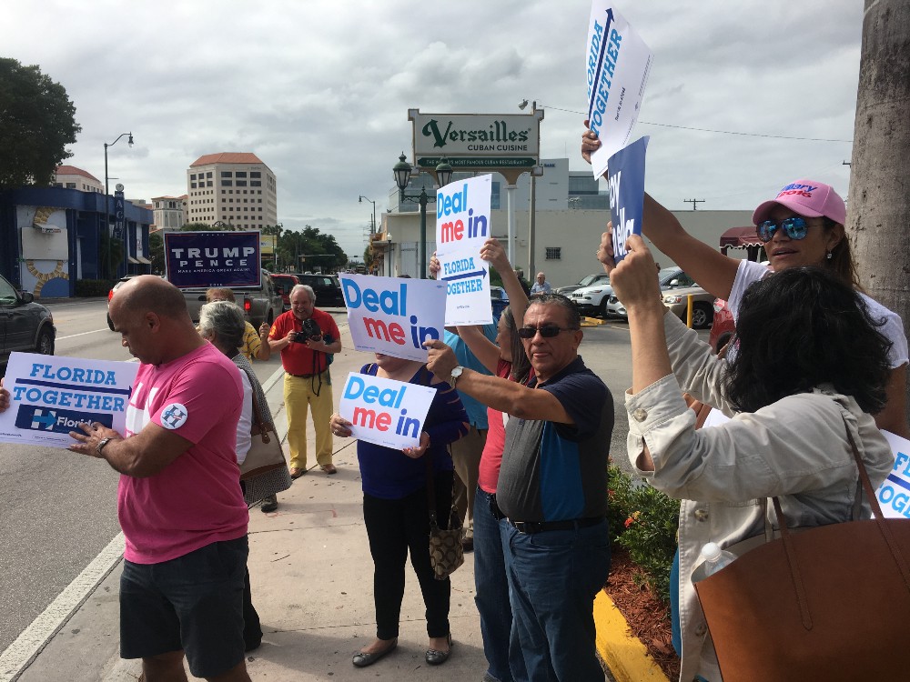Cuban-Americans stand outside the landmark Versailles Restaurant on Calle Ocho. CREDIT: Kira Lerner