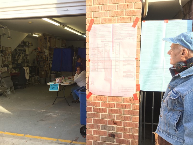 Daniel looking in at the Chobert Decorators Garage in Philadelphia’s Ward 1 which doubles as a polling place on Election Day. CREDIT: Ryan Koronowski