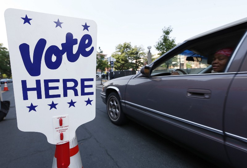 A motorist pulls up to hand off her ballot as voters drop off their ballots in the primary election at a drive-in site outside the city’s election commission headquarters Tuesday, June 28, 2016, in Denver. CREDIT: AP Photo/David Zalubowski