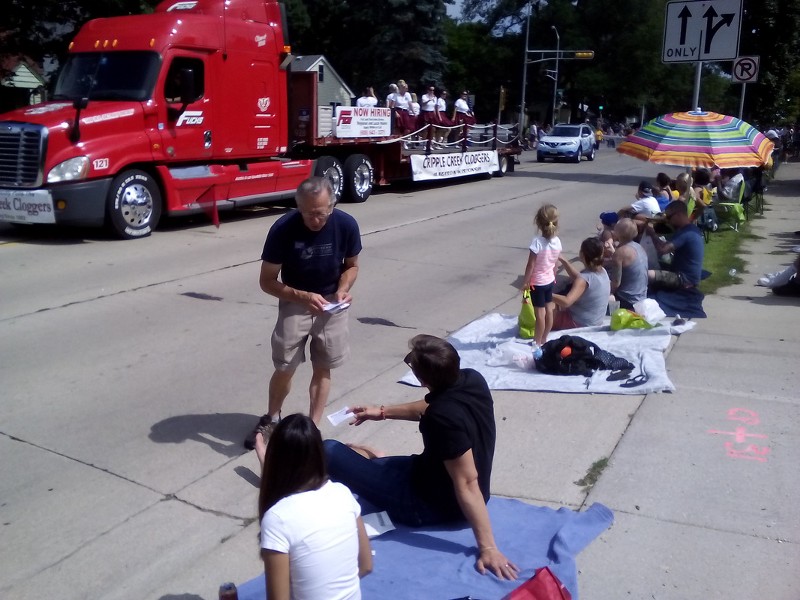 Tony Praza, a Middleton Climate Referendum volunteer, chats with parade goer while leaf-letting for the Middleton Climate Referendum Project at the annual Middleton Good Neighbor Festival Parade. CREDIT: Middleton Climate Referendum