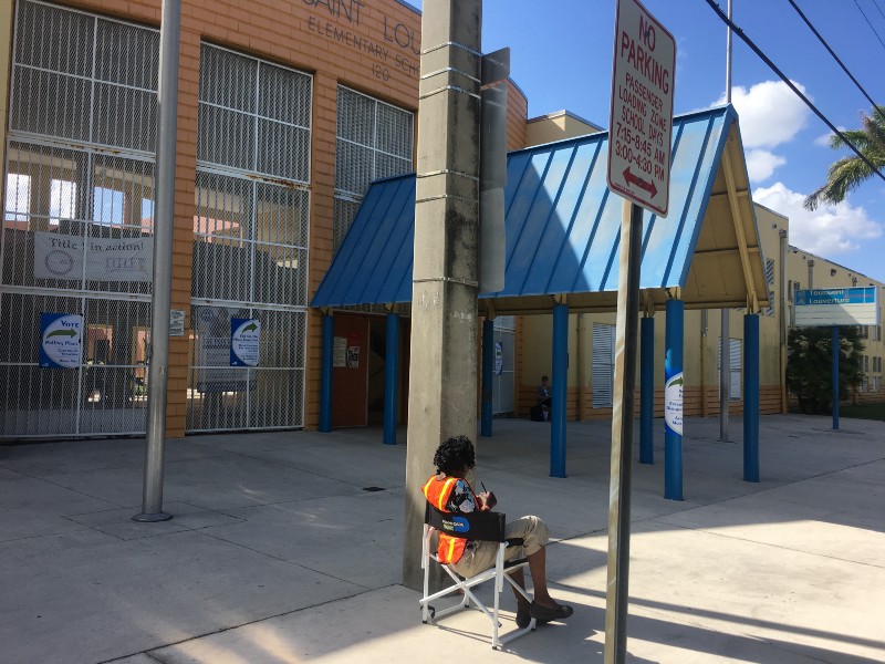 A poll worker watches a polling place in Miami. CREDIT: Kira Lerner