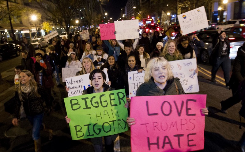 Demonstrators holds banners as they protest during a march in downtown Washington. CREDIT: AP Photo/Jose Luis Magana