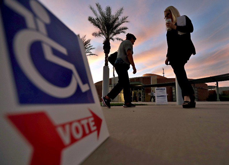 Voters enter and exit from their polling station early, Tuesday, Nov. 8, 2016, in Tempe, AZ. CREDIT: AP Photo/Matt York