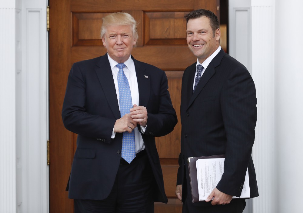 President-elect Donald Trump pauses pose for photographs as he greets Kansas Secretary of State, Kris Kobach. CREDIT: AP Photo/Carolyn Kaster