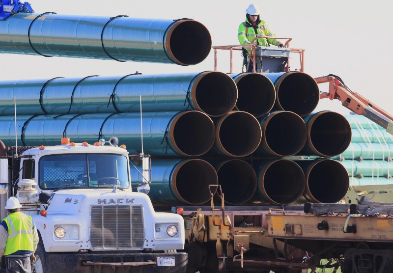 Workers unload pipes for the proposed Dakota Access oil pipeline. CREDIT: AP Photo/Nati Harnik, File