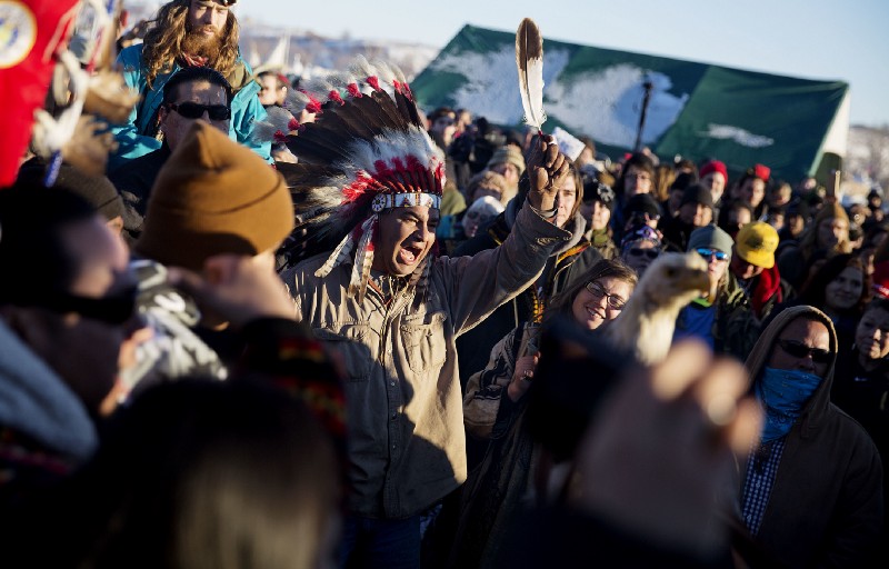 A crowd gathers in celebration at the Oceti Sakowin camp after it was announced that the U.S. Army Corps of Engineers won’t grant easement for the Dakota Access oil pipeline. CREDIT: AP Photo/David Goldman