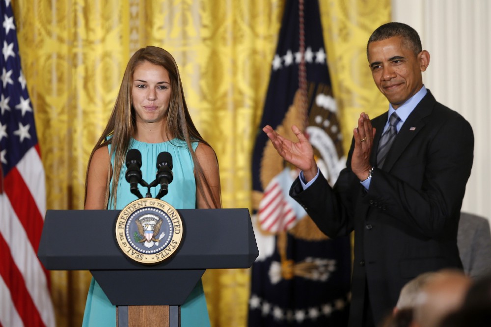 President Barack Obama applauds Victoria Bellucci, a 2014 graduate of Huntingtown High Shool in Huntingtown, Md., who suffered five concussions playing soccer, Thursday, May 29, 2014, in the East Room of the White House in Washington, during the White House Healthy Kids and Safe Sports Concussion Summit. Obama was hosting a summit with representatives of professional sports leagues, coaches, parents, young athletes, researchers and others to call attention to the issue of youth sports concussions. CREDIT: AP Photo/Charles Dharapak