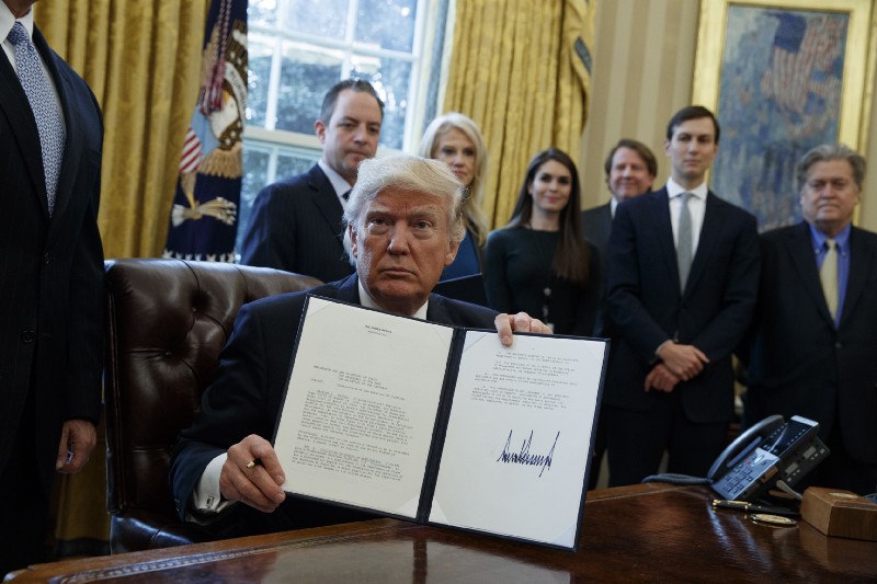 President Donald Trump shows his signature on an executive order on the Keystone XL pipeline, Tuesday, Jan. 24, 2017, in the Oval Office of the White House in Washington. CREDIT: AP Photo/Evan Vucci