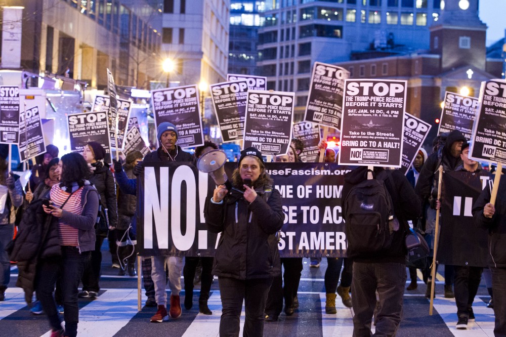 Demonstrators holds banners and signs as they protest during a march in downtown Washington in opposition of President-elect Donald Trump, Sunday, Jan. 15, 2017. CREDIT: AP Photo/Jose Luis Magana