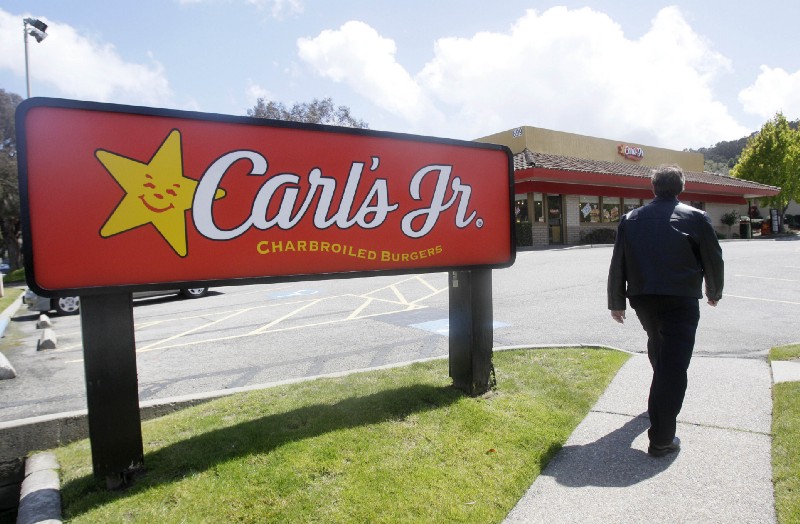 A man walks past a sign for a Carl’s Jr. restaurant in San Bruno, Calif., Wednesday, May 25, 2011. CREDIT: AP Photo/Jeff Chiu