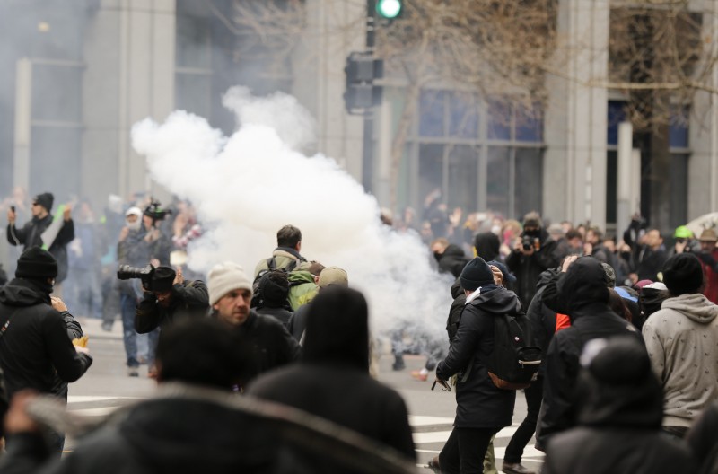 Smoke from a police “sting-ball” grenade rises in a crowd of protesters and cameramen during a police “kettle” of demonstrators on Inauguration Day in Washington, D.C. CREDIT: AP Photo/Mark Tenally