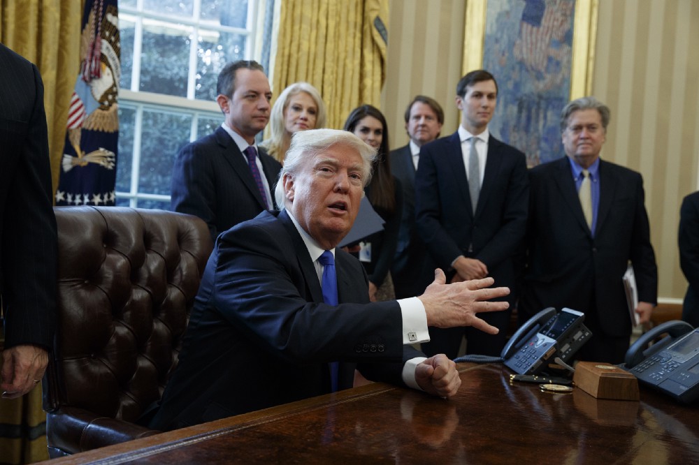 President Donald Trump talks with reporters n the Oval Office of the White House on Tuesday. CREDIT: AP Photo/Evan Vucci
