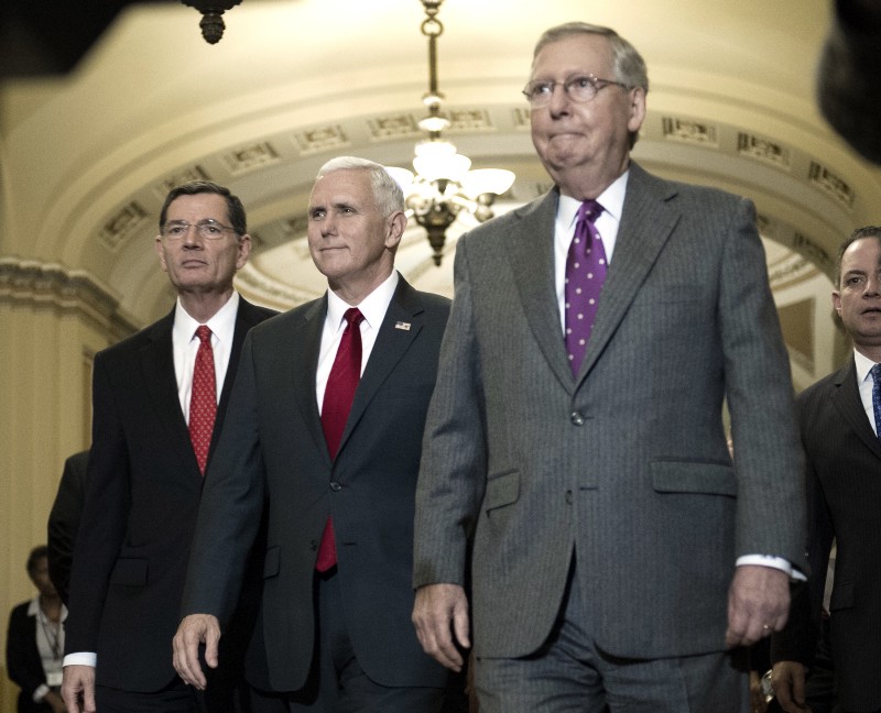 Vice President-elect Mike Pence, flanked by Senate Majority Leader Mitch McConnell and Sen. John Barrasso CREDIT: AP Photo/Cliff Owen