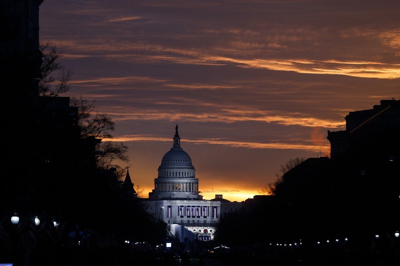 The Capitol Building is illuminated against the sunrise before the presidential inauguration of President Donald Trump. CREDIT: AP Photo/John Minchillo