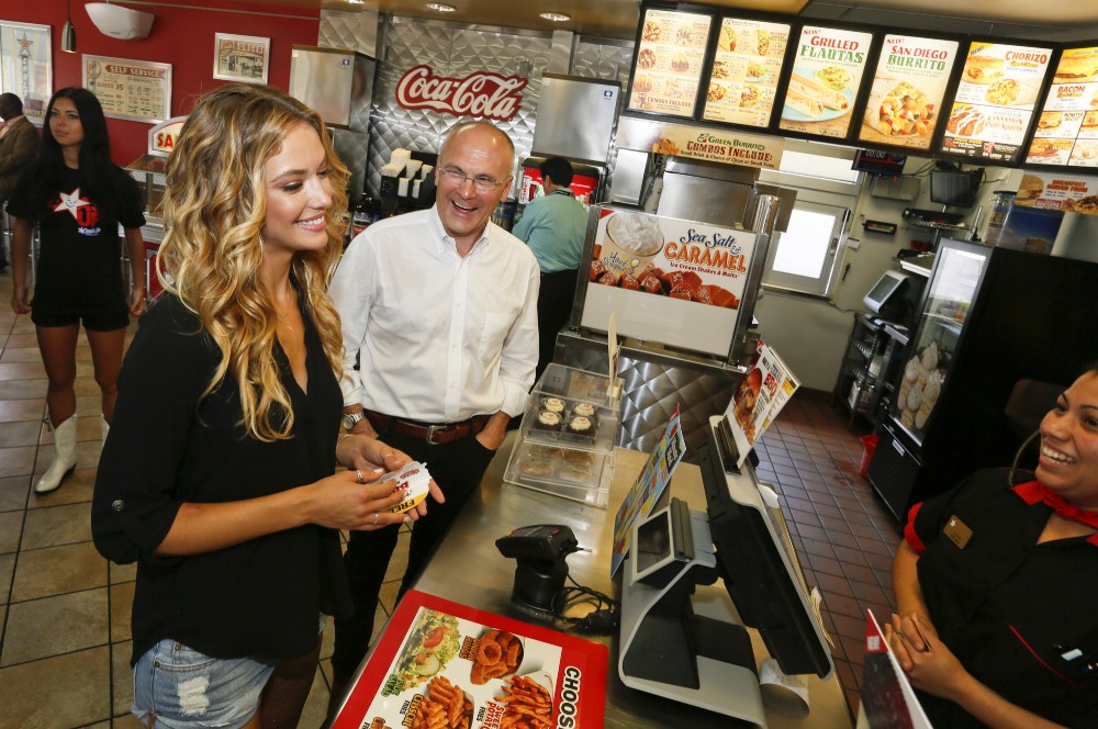 Sports Illustrated swimsuit model Hannah Ferguson, left, orders lunch along side CKE Restaurants CEO Andy Puzder after a news conference on Wednesday, August 6, 2014 in Austin, Texas. CREDIT: Jack Plunkett/AP Images